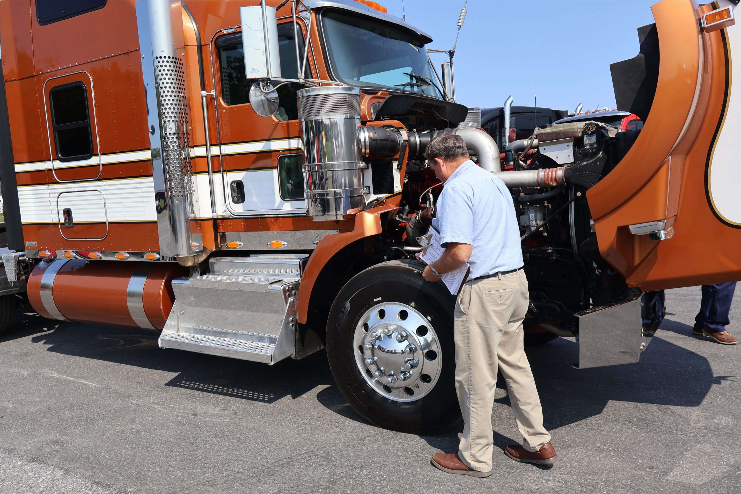 Man inspecting the tire of a Kenworth Truck